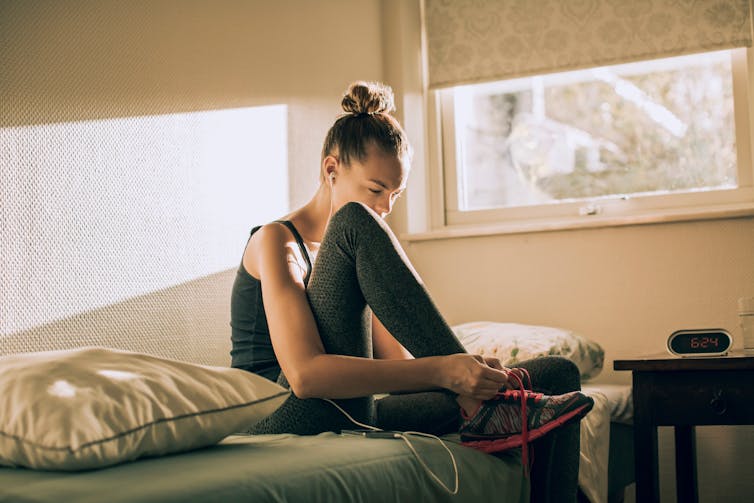 Woman ties running shoes.