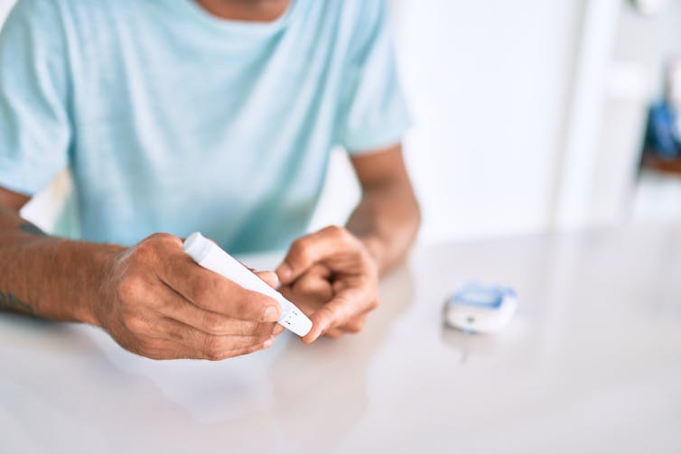 A person performing a finger prick test to measure blood sugar levels.